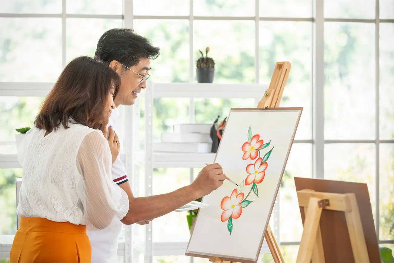 Couple painting and admiring a floral painting